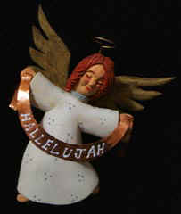 July 2006 - This is the fourth piece of the 15 piece nativity scene. The flying angel is carved from basswood, finished with acrylics and stands about 7 inches tall but it will be position on a 12 inch dowel so it appears to be flying above the stable. The large ribbon the angel is holding is made from a thin piece of copper and text painted with acrylics.